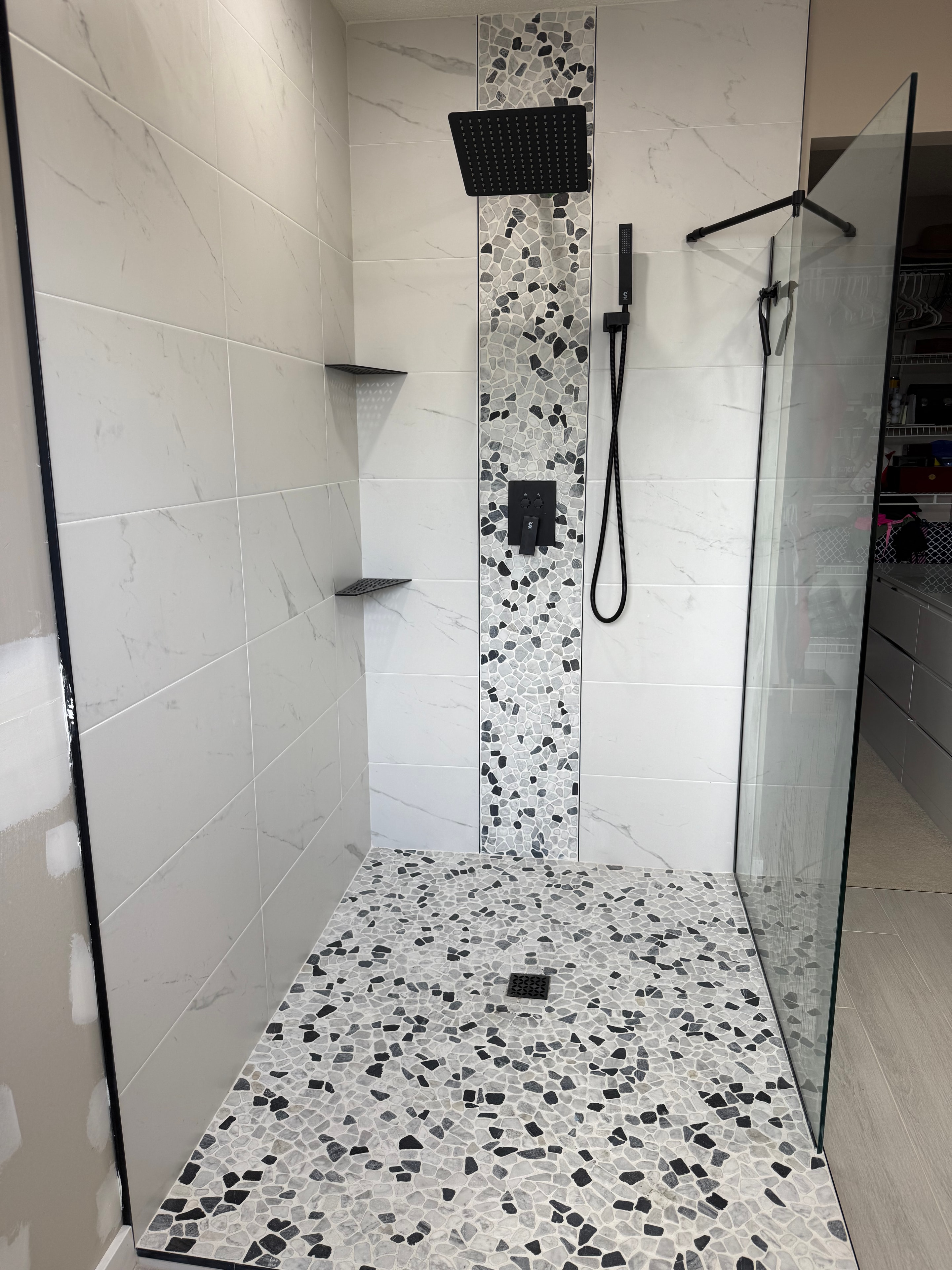 Custom shower with marble-look tile and matte black fixtures